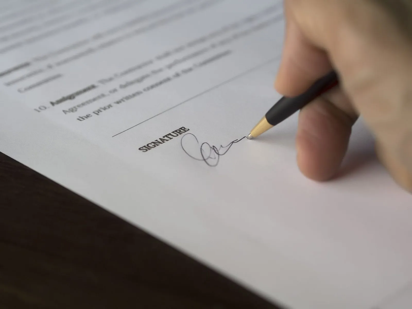 Primer plano de la firma de un contrato mercantil